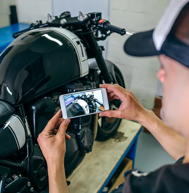 Persona fotografiando una motocicleta como evidencia del accidente.
