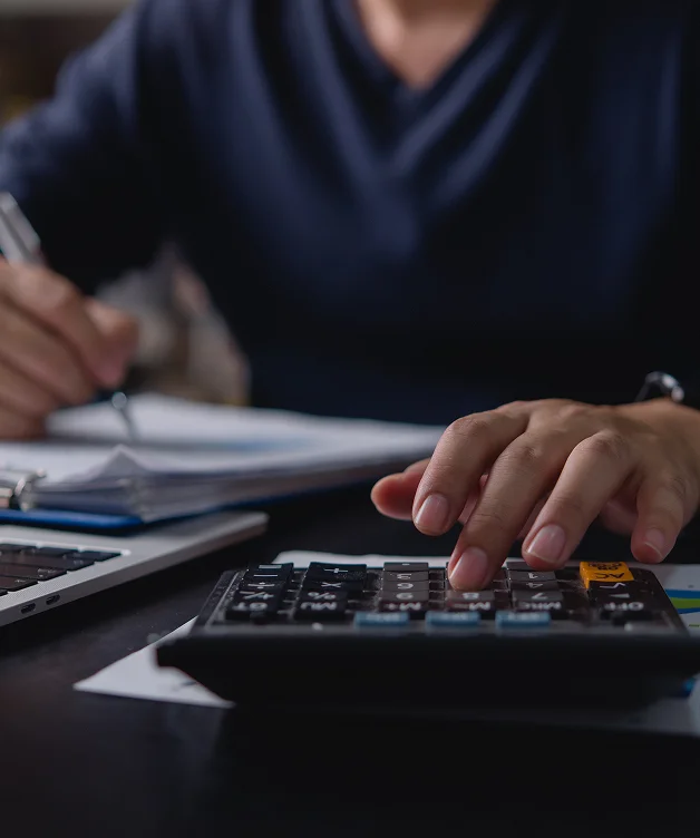 Persona calculando gastos y documentos para estimar una compensación.