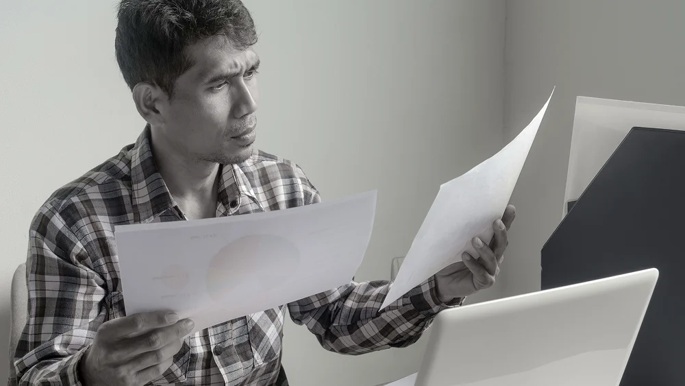 Trabajador firmando un documento sin leerlo con atención.