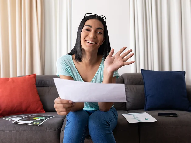 Mujer sonriente revisando un documento de acuerdo de compensación.