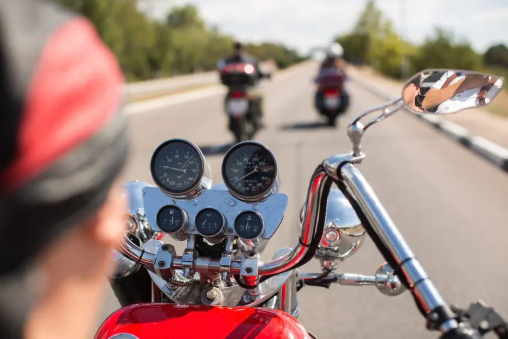 Vista desde una motocicleta roja hacia otros motociclistas en la carretera.