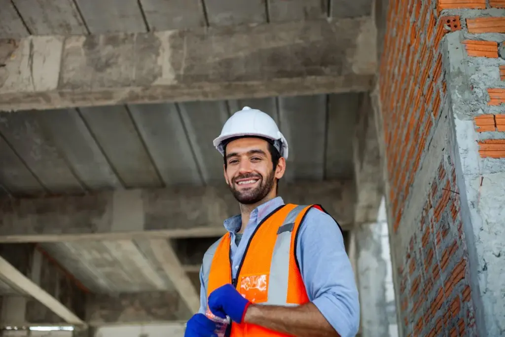 Trabajador de construcción con equipo de seguridad en una obra, en referencia a la compensación por lesión laboral.