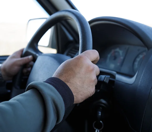 Manos de un conductor sujetando el volante de un vehículo.